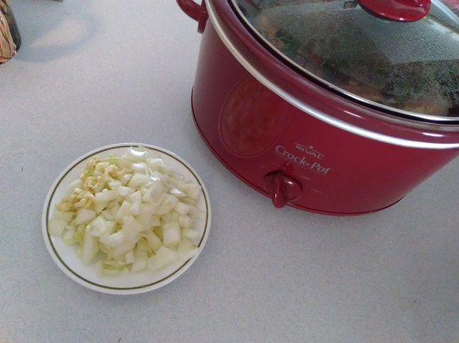 onions and garlic next to a crock pot